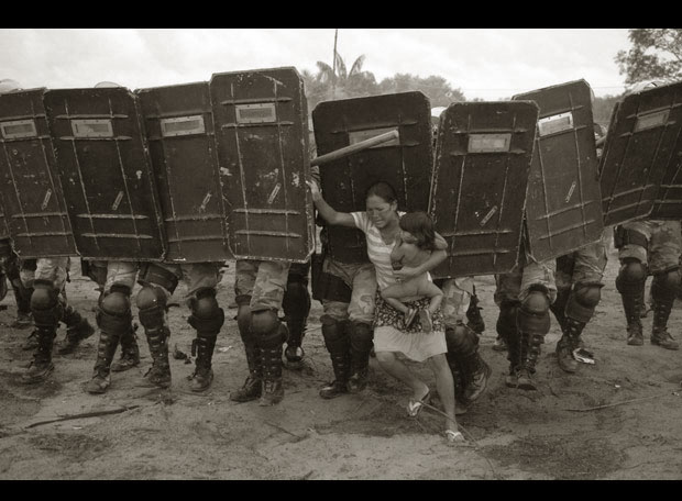Primer premio; categoría General News Singles  Una mujer intenta resistir el desalojo policial de los okupas en terrenos privados cerca de la ciudad de Manaos, en Amazonas, en Brasil. Se había avisado a las familias que viven allí del desalojo días antes. Los ocupantes, que protestaban contra la falta de vivienda en Manaos, fueron expulsados después de un enfrentamiento que duró dos horas. Foto tomada el 10 de marzo. Fotografía de Luiz Vasconcelos. elpais.com